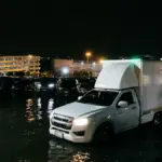 Flooded streets in Bangkok with vehicles submerged during disaster zone declaration