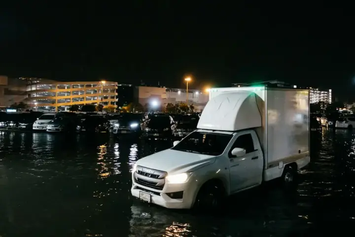 Flooded streets in Bangkok with vehicles submerged during disaster zone declaration