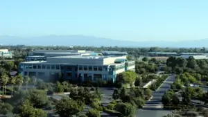 Wide-angle photograph of the Cisco Systems corporate headquarters campus and glass exterior office complex in San Jose, California.