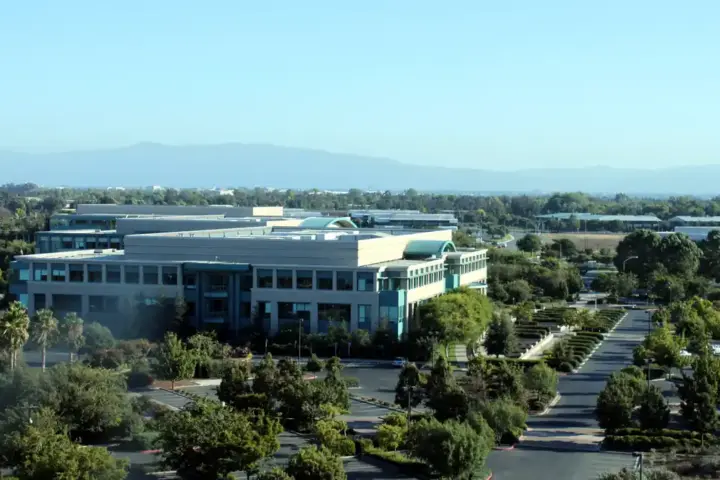 Wide-angle photograph of the Cisco Systems corporate headquarters campus and glass exterior office complex in San Jose, California.