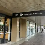 Exterior glass entrance and official signage of a Services Australia Centrelink branch location