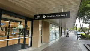 Exterior glass entrance and official signage of a Services Australia Centrelink branch location