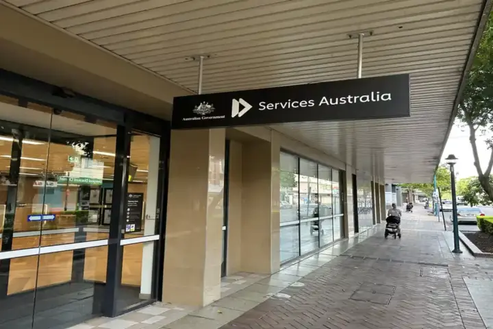 Exterior glass entrance and official signage of a Services Australia Centrelink branch location