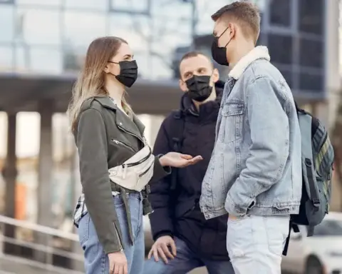 People wearing face masks in an urban setting, illustrating COVID-19 respiratory-virus coverage in Australia