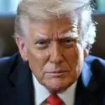 Official portrait of Donald Trump seated at the Resolute Desk in the Oval Office.