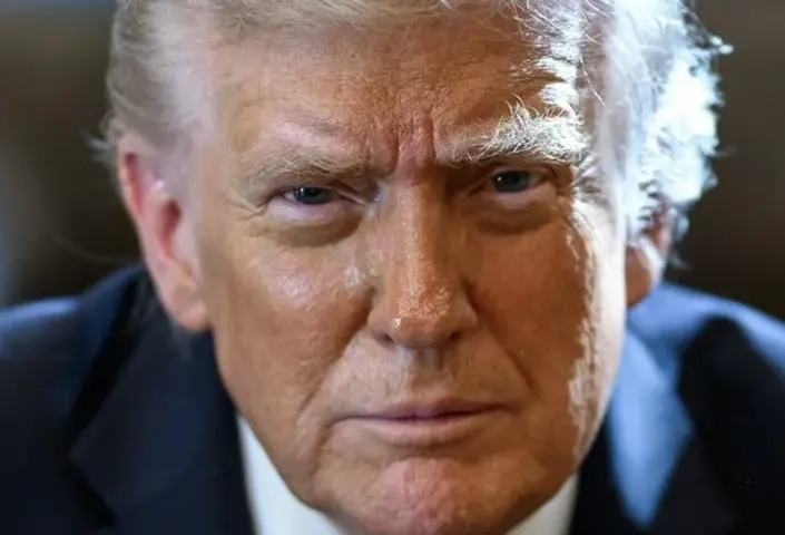 Official portrait of Donald Trump seated at the Resolute Desk in the Oval Office.