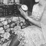 Woman adjusting a clock after the end of daylight saving time.