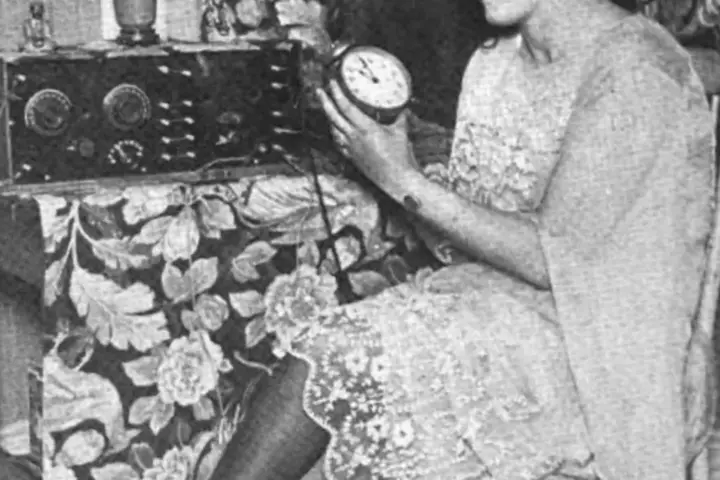 Woman adjusting a clock after the end of daylight saving time.