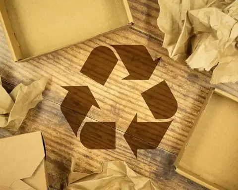 Recycling symbol surrounded by cardboard boxes and paper packaging