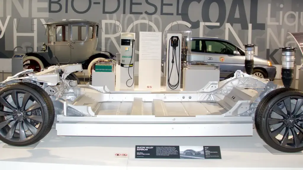 Exposed structural chassis of an electric passenger vehicle displaying the sealed underfloor traction battery compartment and electric motor drives.