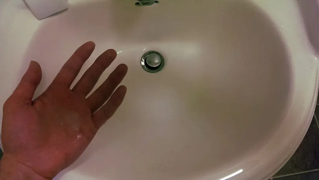 Liquid hand soap beside a bathroom sink