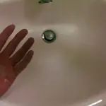 Liquid hand soap beside a bathroom sink