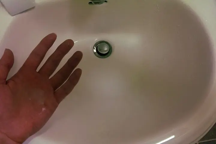 Liquid hand soap beside a bathroom sink