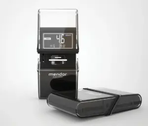 Photograph of a digital blood glucose meter with a test strip and detachable components on a white background.