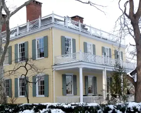 Exterior front facade of Gracie Mansion surrounded by trees and snow in Manhattan’s Carl Schurz Park.