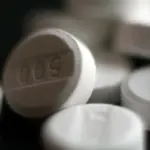 Close-up photograph of white pharmaceutical acetaminophen 500 milligram tablets on a neutral surface
