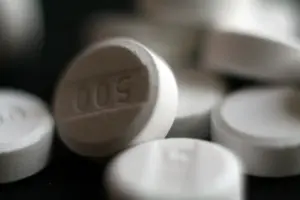 Close-up photograph of white pharmaceutical acetaminophen 500 milligram tablets on a neutral surface