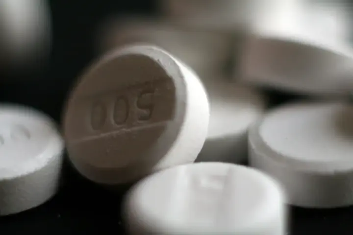 Close-up photograph of white pharmaceutical acetaminophen 500 milligram tablets on a neutral surface