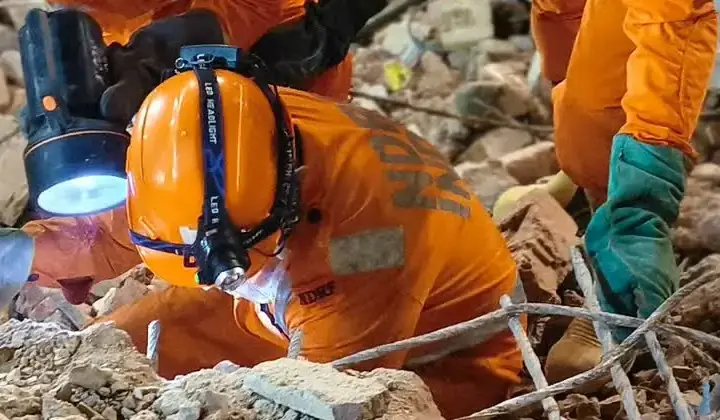 NDRF rescuers search through rubble after the Satya Niketan building collapse in Delhi.