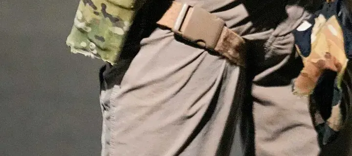 Cropped view of tactical gear worn by enforcement officers during an immigration operation in Florida.