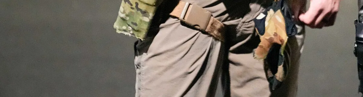 Cropped view of tactical gear worn by enforcement officers during an immigration operation in Florida.