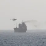 High-angle aerial photograph of a loaded commercial motor tanker vessel transiting open international waters in the Gulf region.