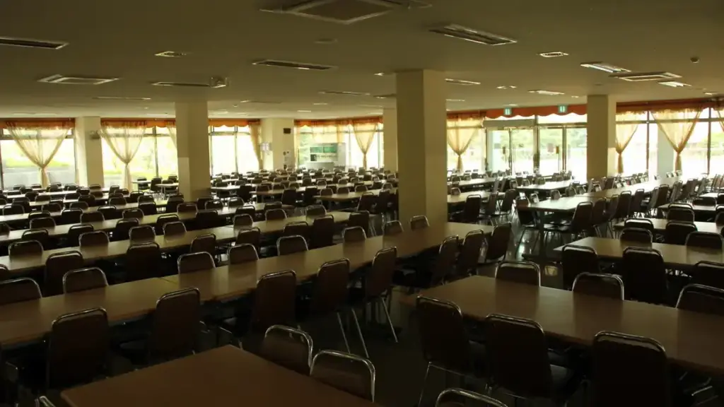 An empty school classroom with rows of desks and chairs.