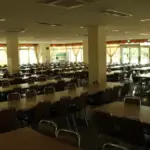 An empty school classroom with rows of desks and chairs.