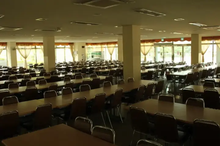An empty school classroom with rows of desks and chairs.