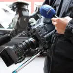 A professional broadcast television camera positioned inside a studio.