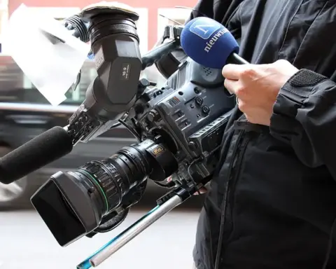 A professional broadcast television camera positioned inside a studio.