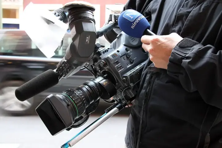 A professional broadcast television camera positioned inside a studio.