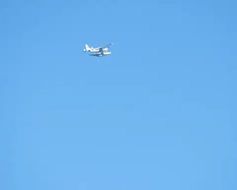 Cessna 208 Caravan aircraft flying over coastal water during approach