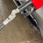 Fuel nozzle inserted into a car during refilling at a petrol station
