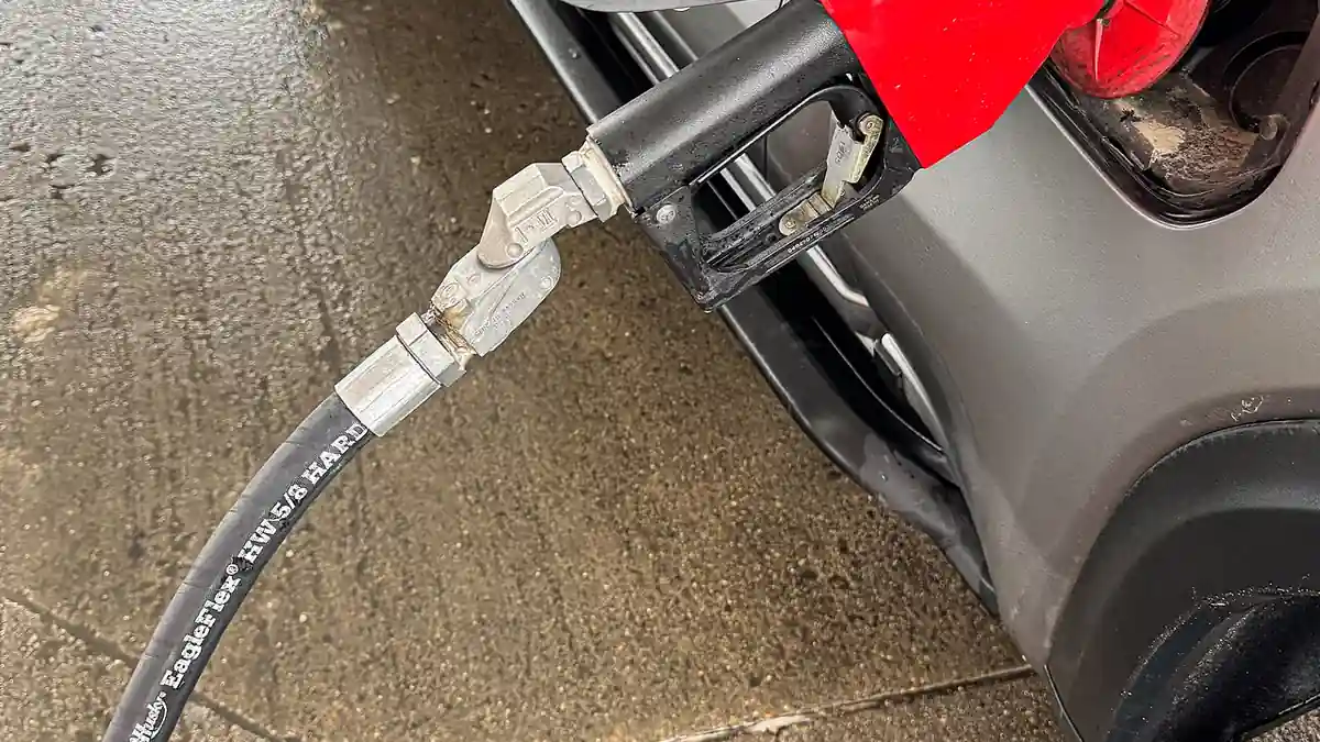 Fuel nozzle inserted into a car during refilling at a petrol station
