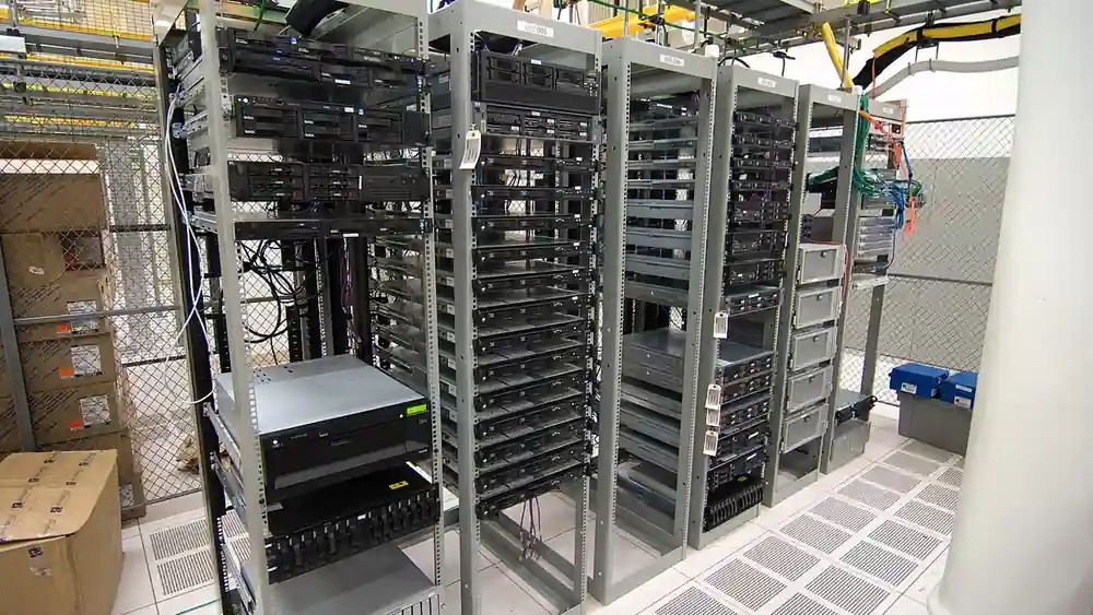 Server cabinet racks with illuminated status indicators and network cabling in a data facility