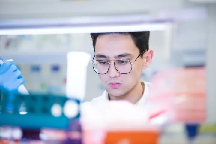 Researcher using laboratory pipettes for biological research