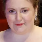 Actress, writer, and director Lena Dunham smiling on the red carpet during the 74th Berlin International Film Festival.