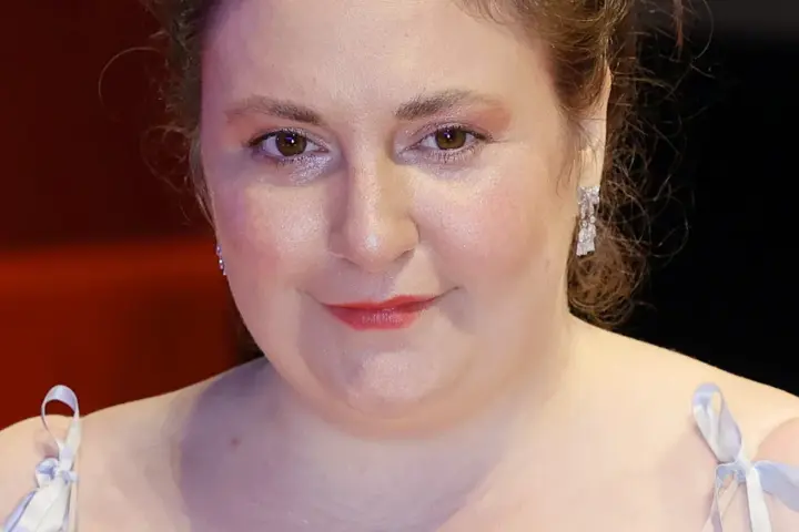 Actress, writer, and director Lena Dunham smiling on the red carpet during the 74th Berlin International Film Festival.