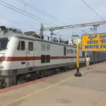 Indian Railways electric locomotive at a railway station.