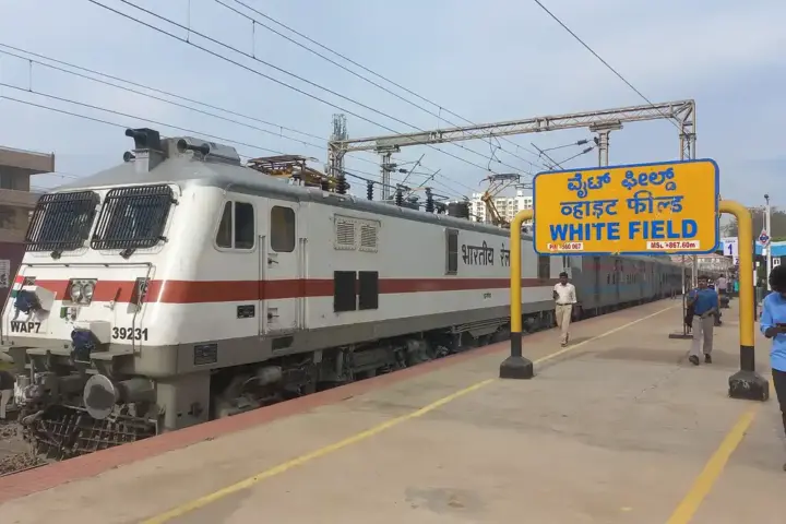 Indian Railways electric locomotive at a railway station.