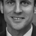 Portrait of French President Emmanuel Macron in a dark suit.