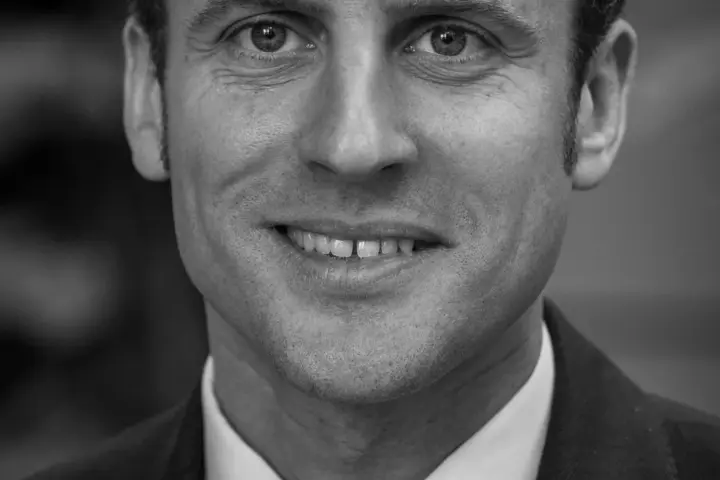 Portrait of French President Emmanuel Macron in a dark suit.