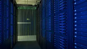 Racks of network servers and glowing fiber-optic cabling in a high-density enterprise data center.