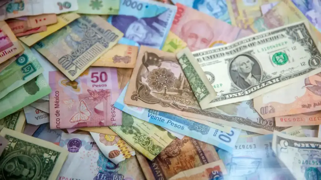 U.S. dollar and Mexican peso banknotes placed together to illustrate currency exchange rates.