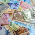 U.S. dollar and Mexican peso banknotes placed together to illustrate currency exchange rates.