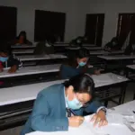 Students seated at desks while taking a Grade 12 written examination