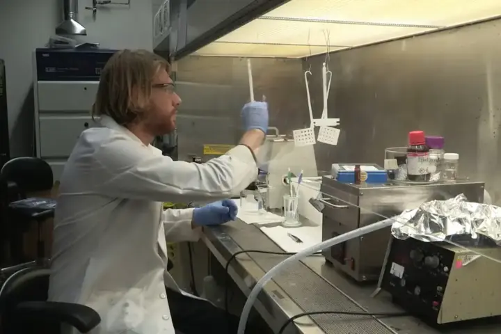 A scientist working in a laboratory, representing the research environment behind the US $144 million microplastics research initiative.