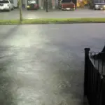 Floodwater covering an urban street after heavy rain.