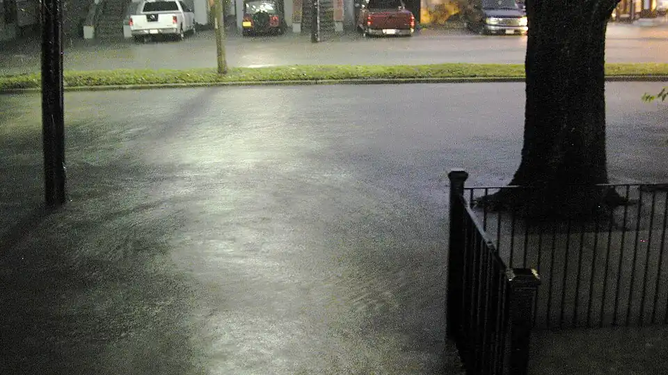 Floodwater covering an urban street after heavy rain.
